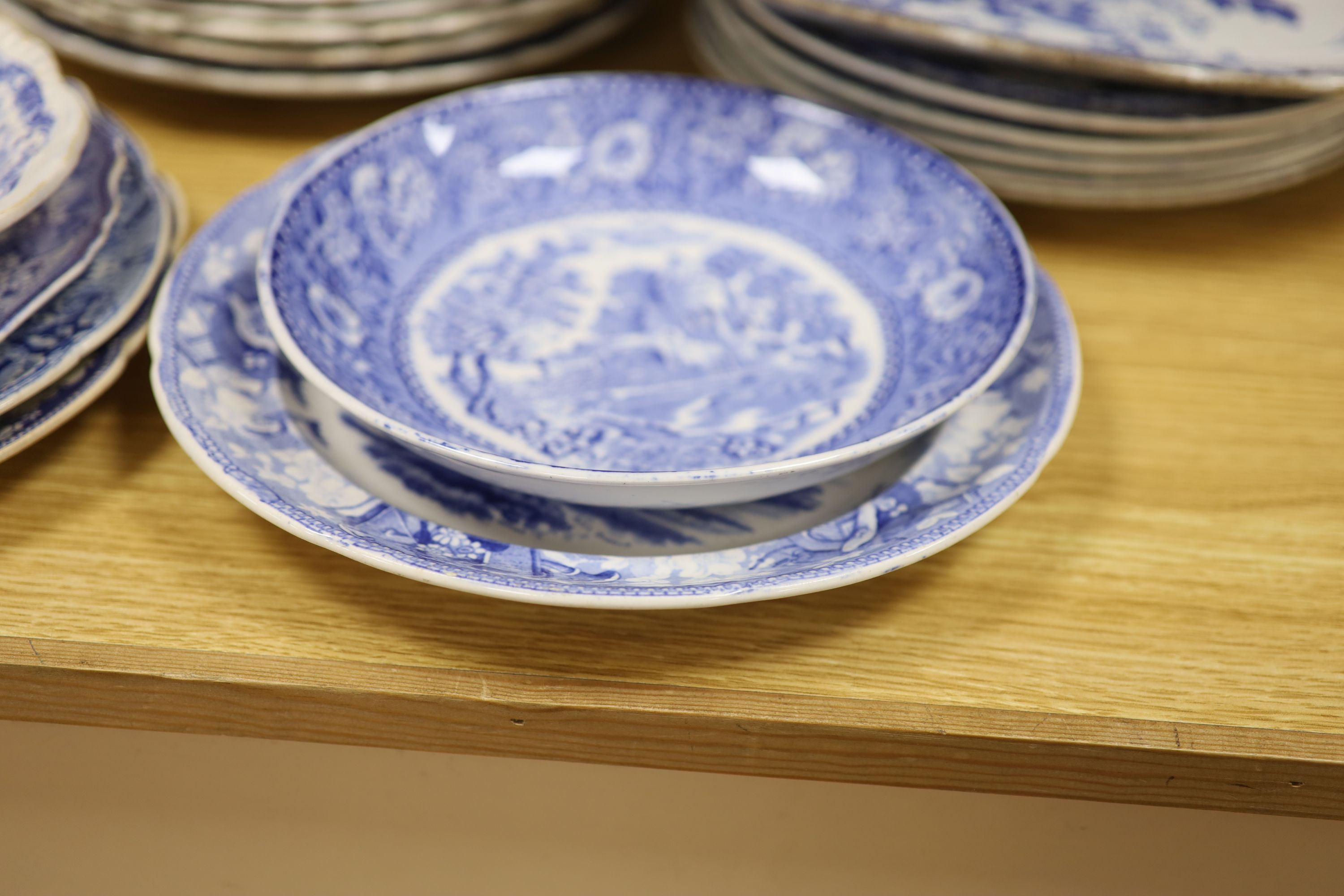 A collection of 19th and 20th century blue and white pottery plates and dishes